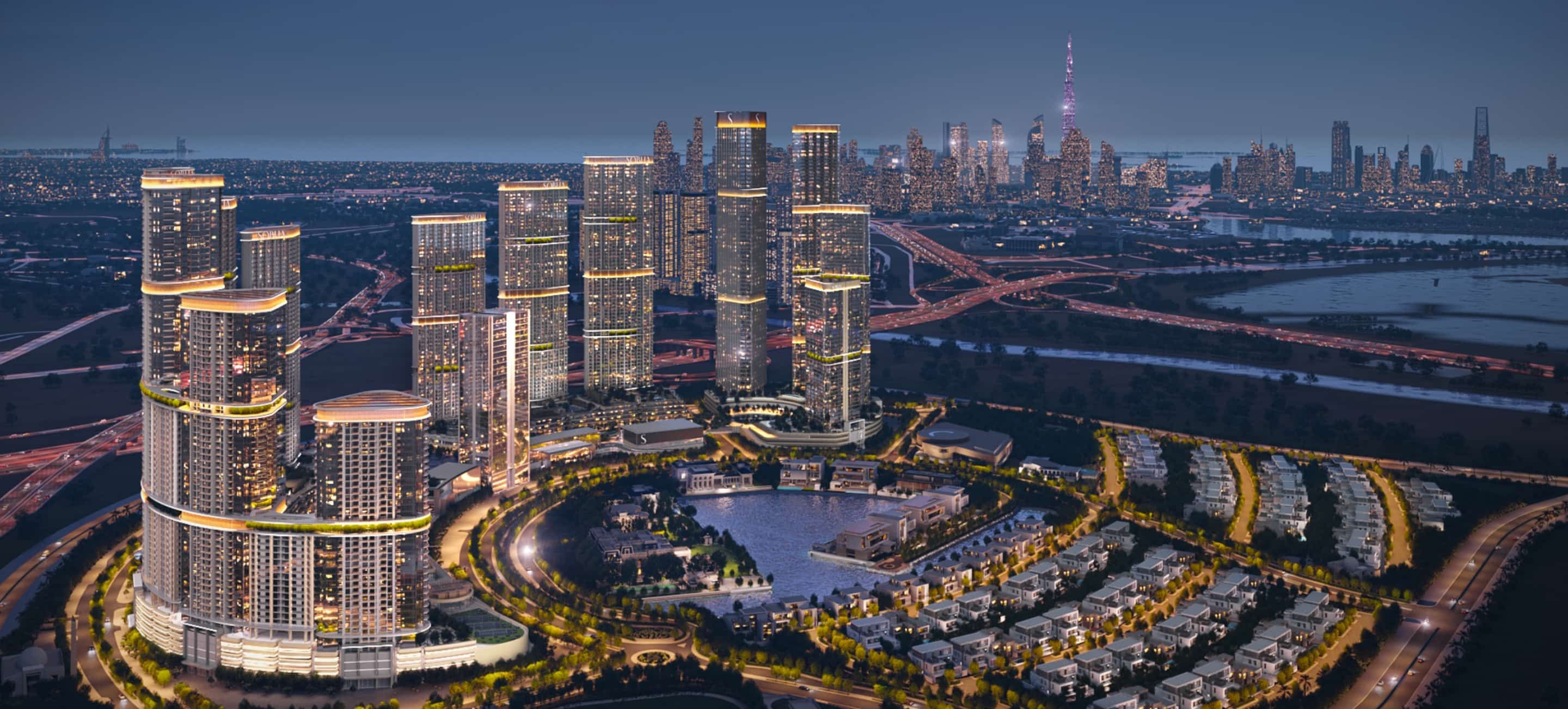 Night aerial of the community with the Dubai skyline behind
