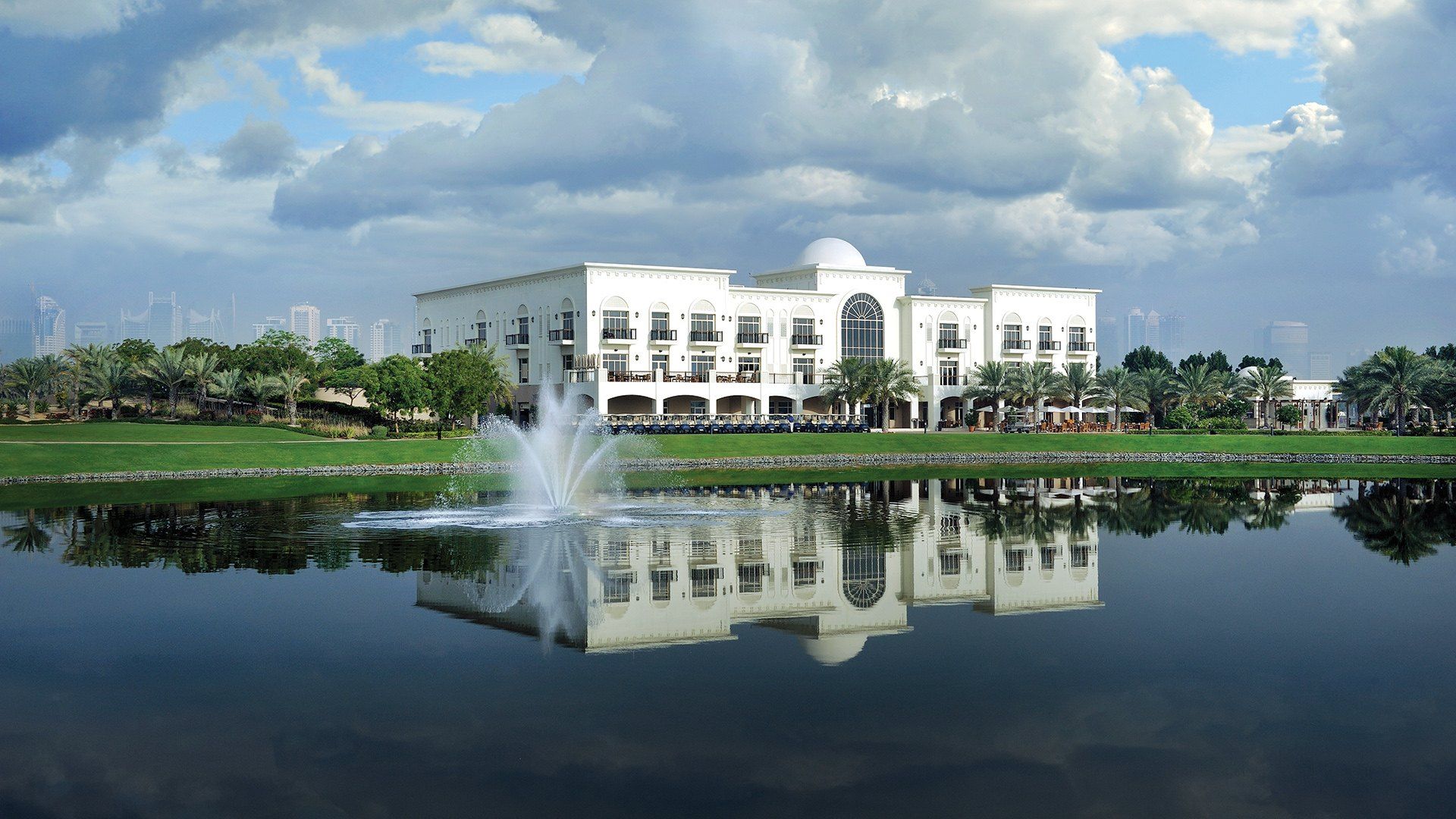 Community clubhouse across a lake with a fountain
